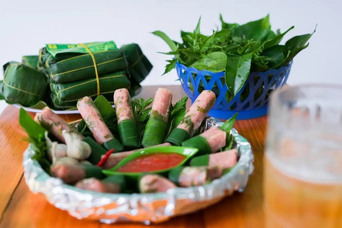 Nem chua Thanh Hóa cắt lát cùng tỏi ớt rau thơm trên bàn ăn