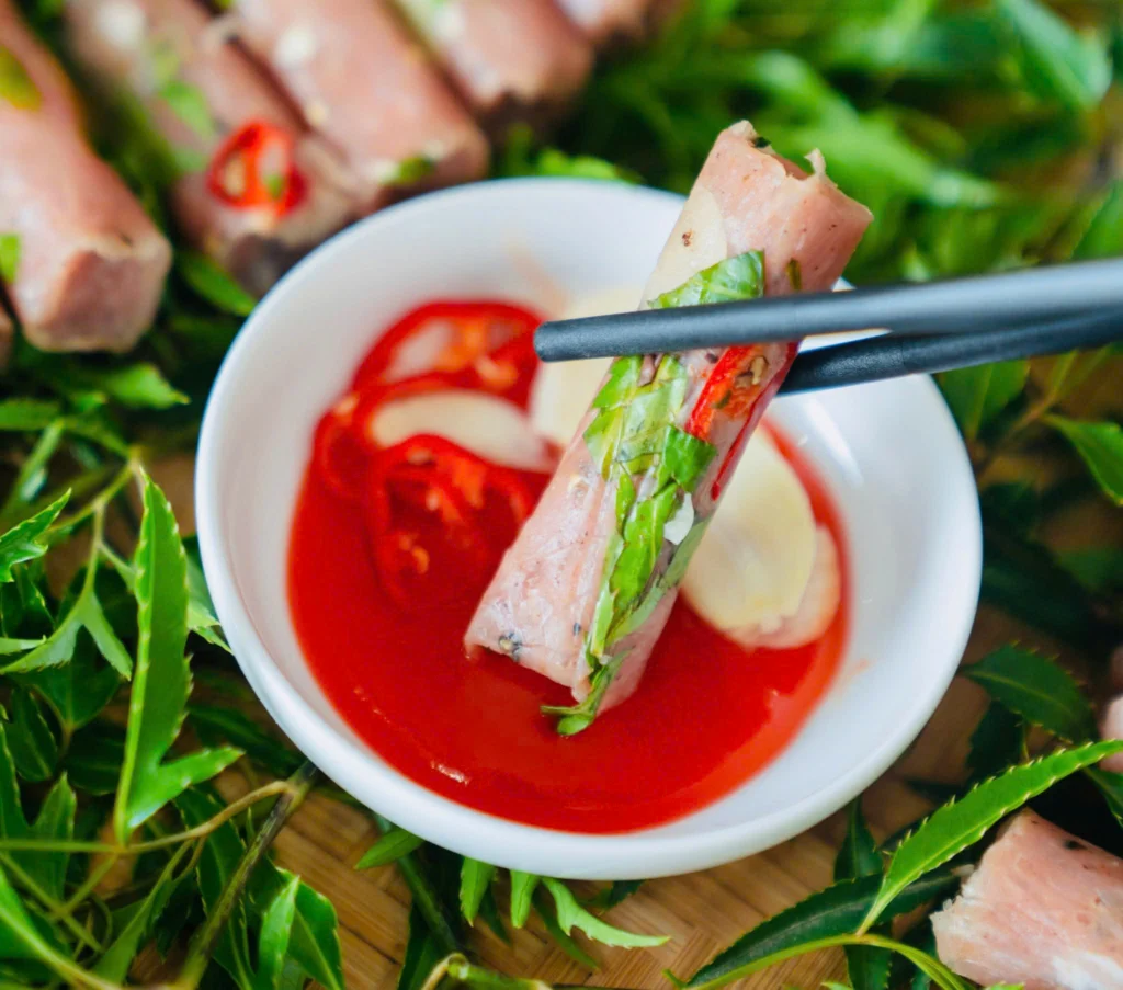 Nem vuông Nem Xứ Thanh được gắp qua bát chấm để thử vị cùng tương Nam Đàn