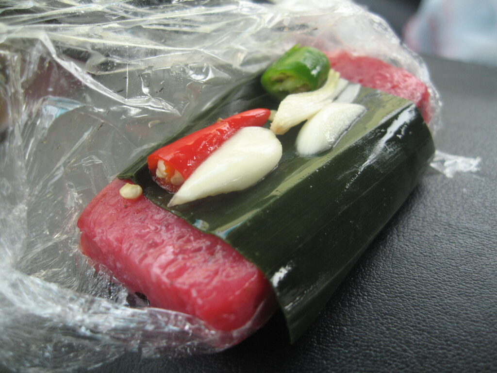 Nem chua gói lá xếp cùng rau thơm. Ảnh: Ron Diggity/Wikimedia Commons, CC BY 2.0.